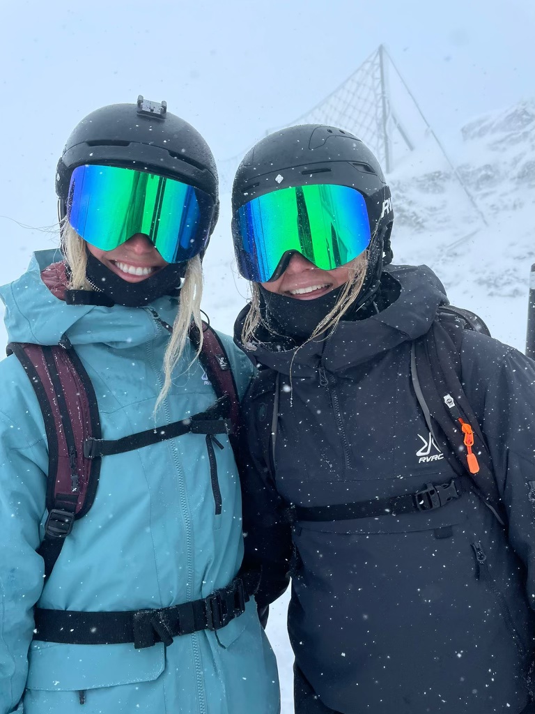 Girls smiling in ski gear with goggles and helmets