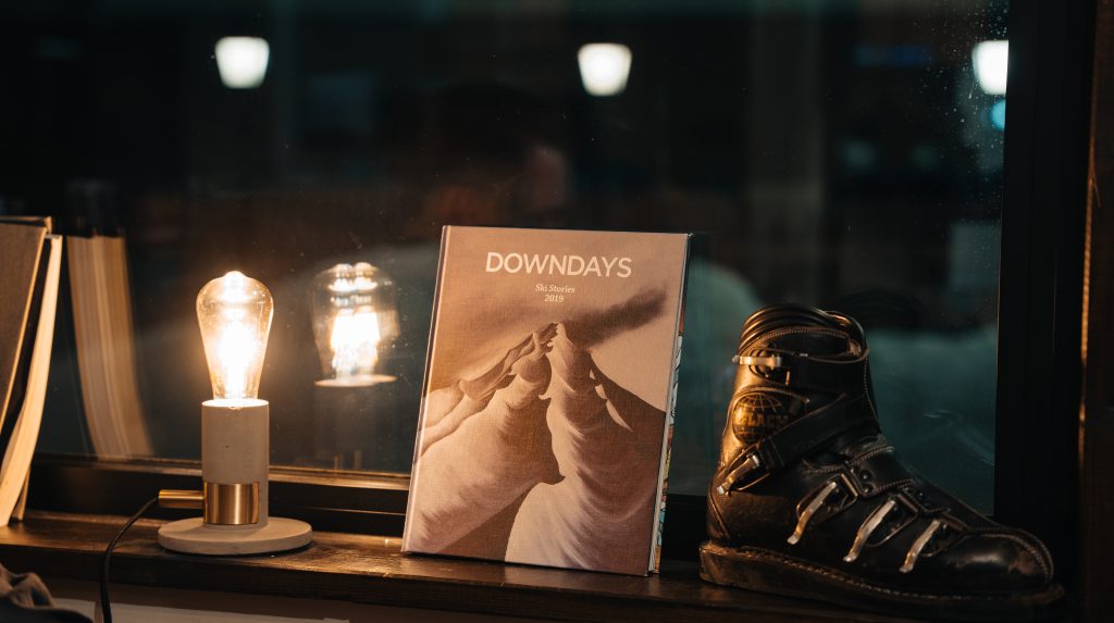 Book titled Downdays on a window sill next to an old ski boot.