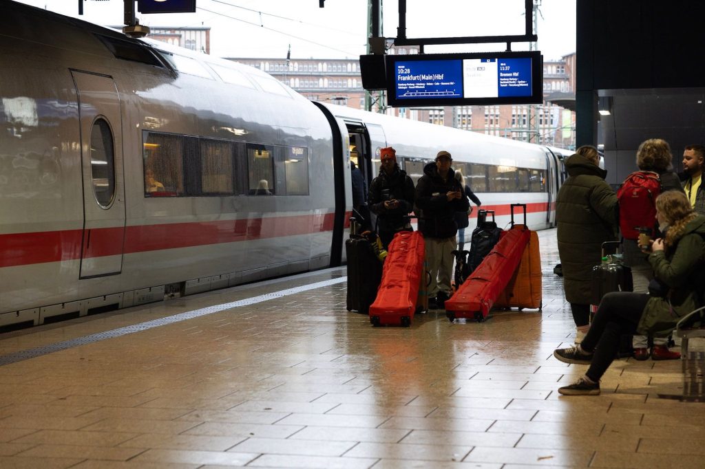 Skiers walking next to a train with ski bags.