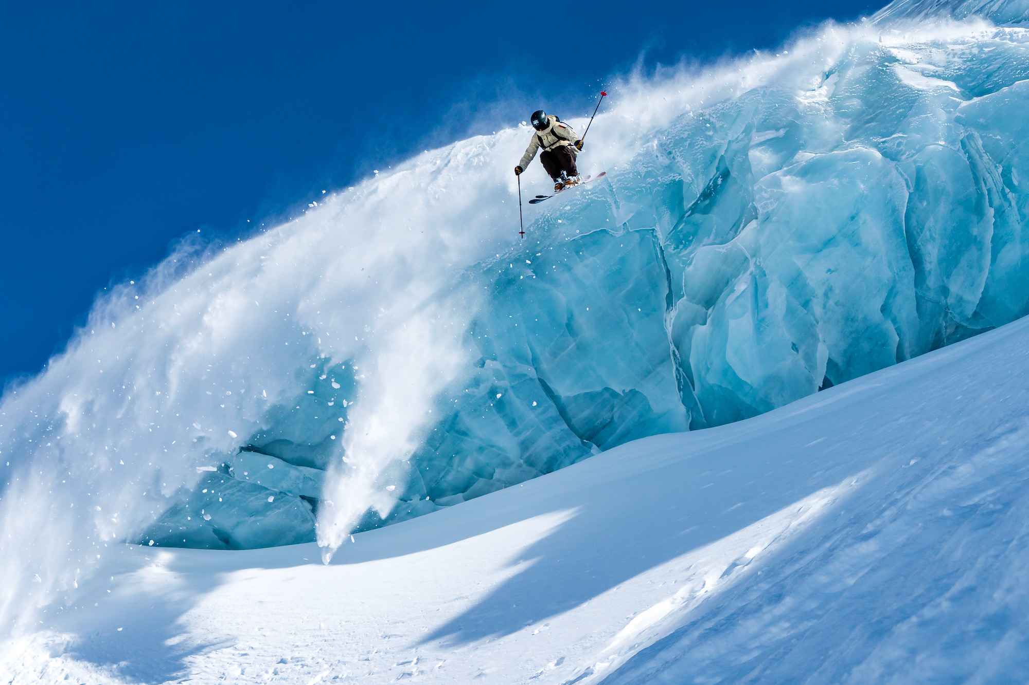 Skier jumping off a large block of ice in Steinberg glacier.