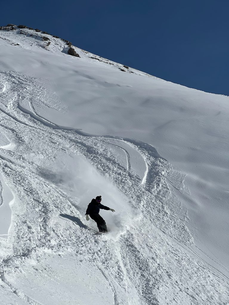 Skitouring and snowboard touring in Bannalp. Snowboarder ripping down in fresh pow.