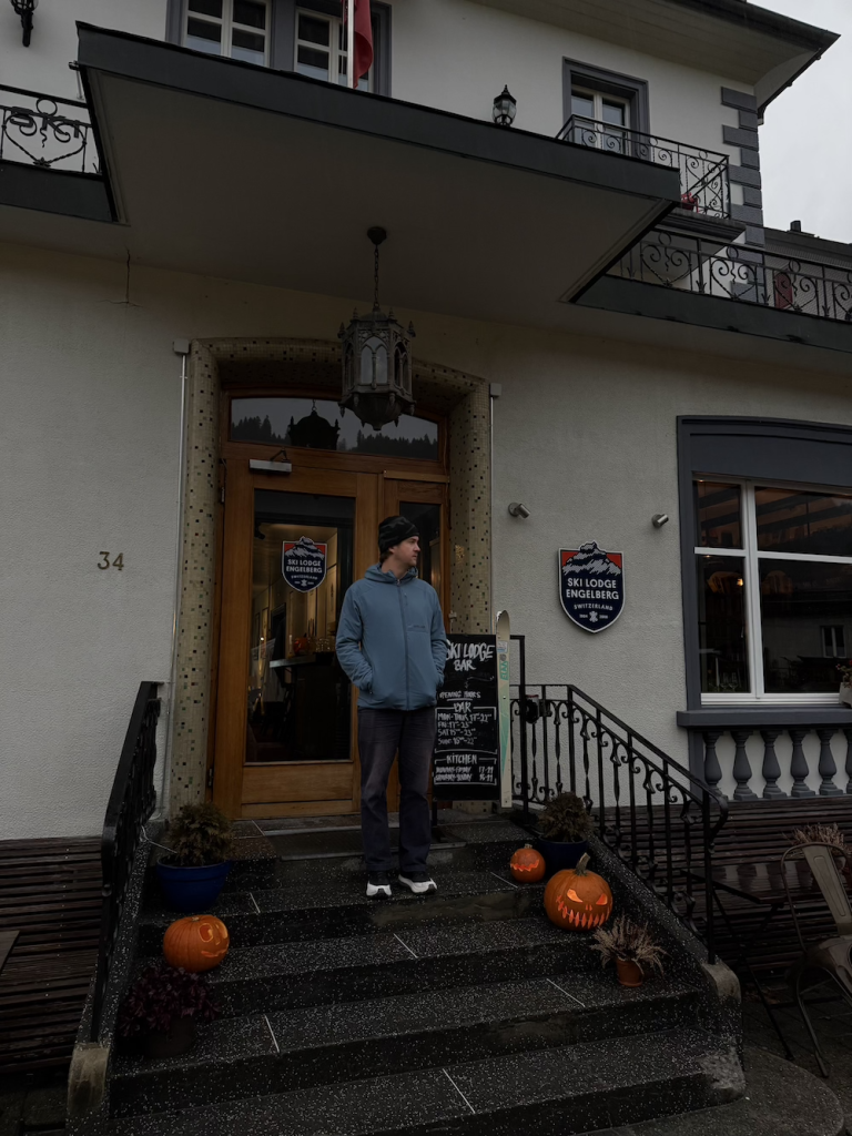 Oliver on the stairs of Ski Lodge Engelberg, with the pumpkins